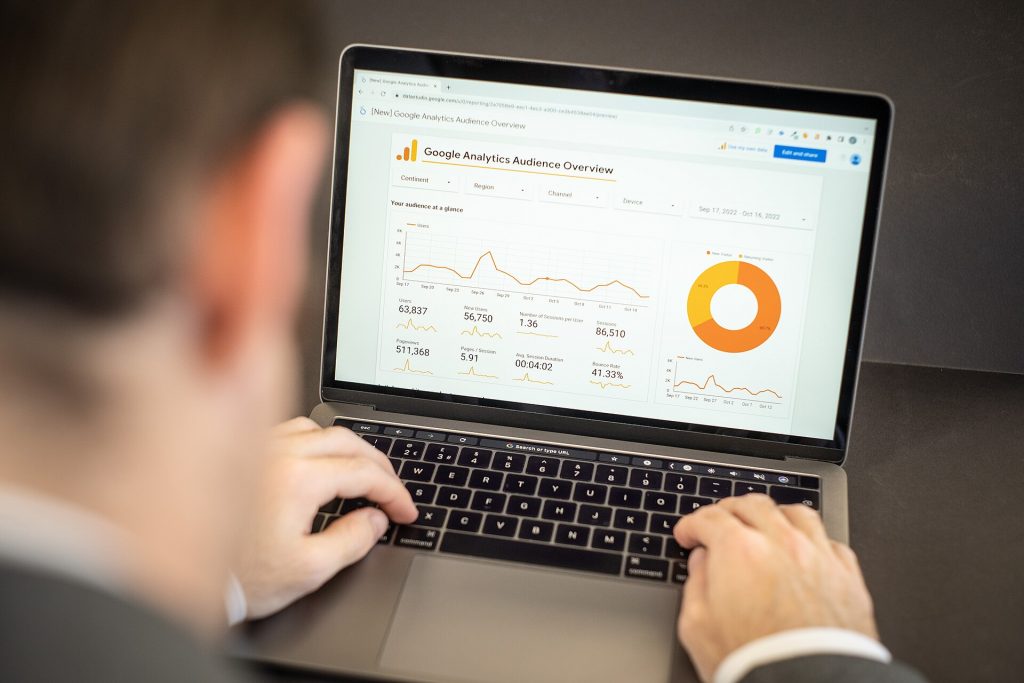 Person viewing a website analytics dashboard with charts on a laptop screen
