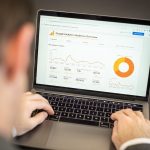 Person viewing a website analytics dashboard with charts on a laptop screen