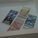 Several printed tourist brochures and leaflets lying in a white display tray