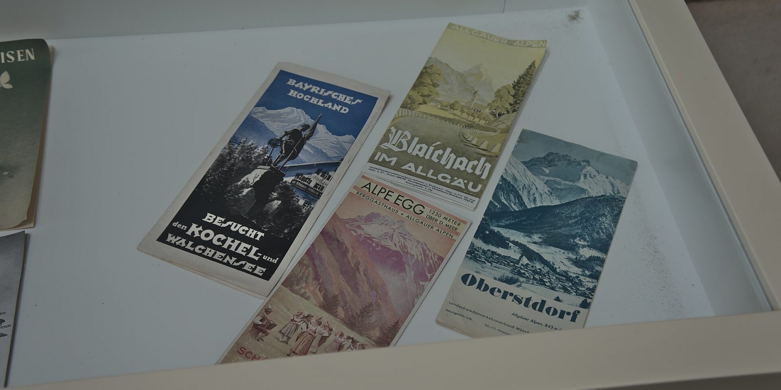 Several printed tourist brochures and leaflets lying in a white display tray