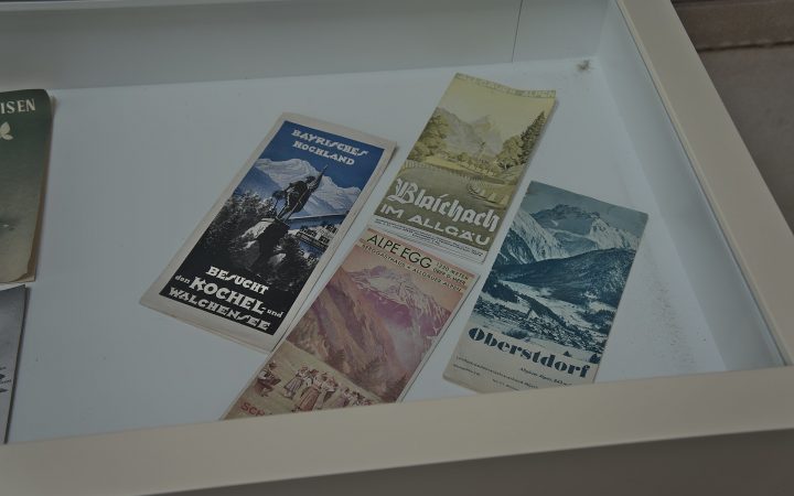 Several printed tourist brochures and leaflets lying in a white display tray