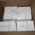 Box of freshly printed business cards in banded stacks