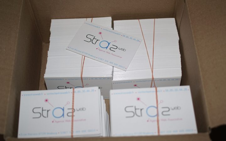 Box of freshly printed business cards in banded stacks