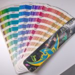 Fanned-out Pantone colour swatch guide showing rows of printed colour chips