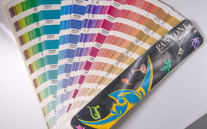 Fanned-out Pantone colour swatch guide showing rows of printed colour chips