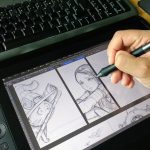 Artist drawing a comic page with a stylus on a pen display graphics tablet