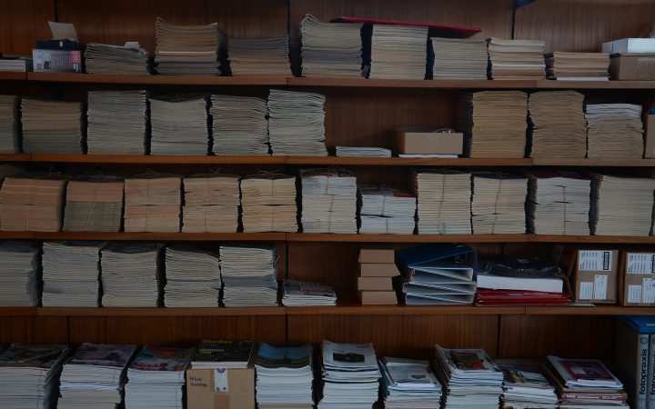Shelves holding many neat stacks of photography and computer magazines