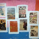 Colourful festival posters pasted on a brightly painted pink and blue wall