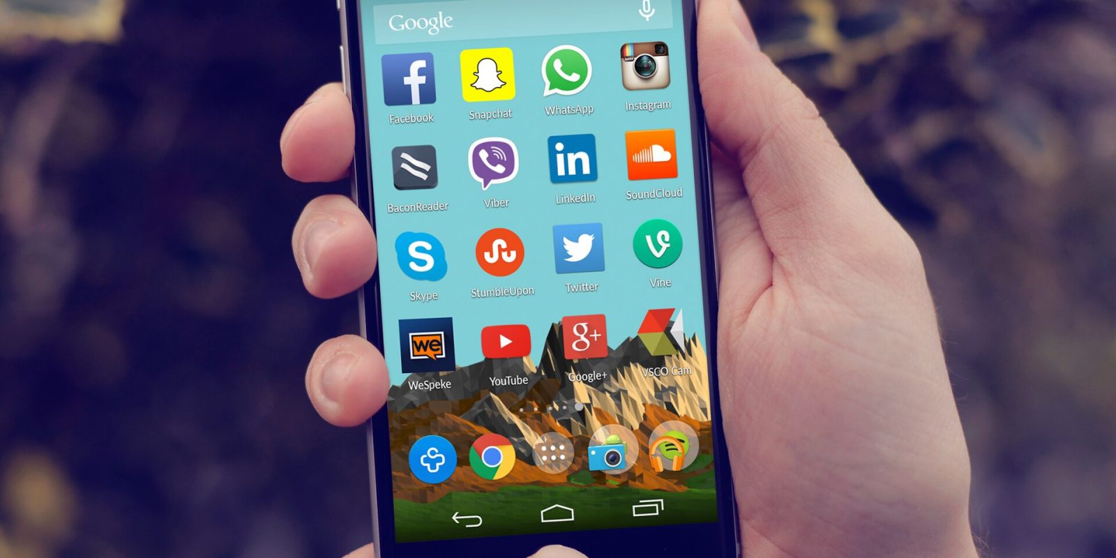 Hand holding an Android smartphone showing social media app icons on the home screen