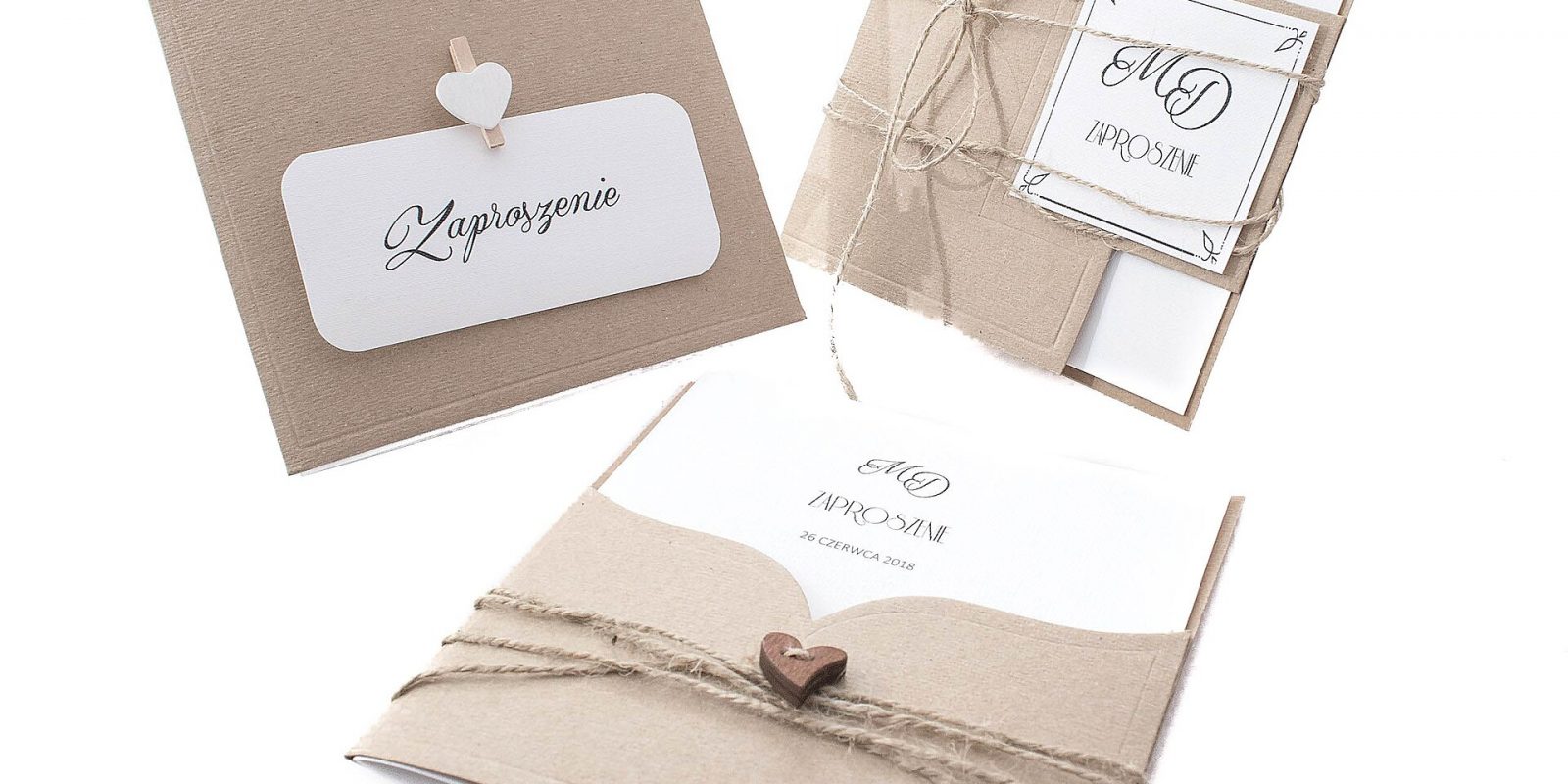 Rustic kraft-paper wedding invitation cards with twine and heart details on white